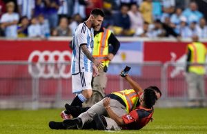 Watch bizarre moment fan runs on pitch and asks Messi to sign his BACK.. before security almost barge PSG ace to floor